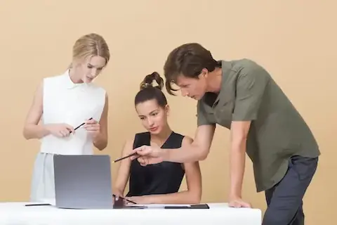 Trei tineri pregătesc un articol pentru publicare